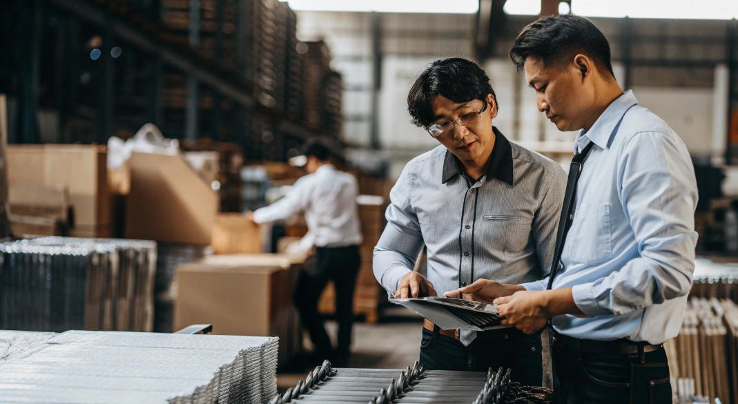 China sourcing agent and supplier in suits and ties standing in a warehouse