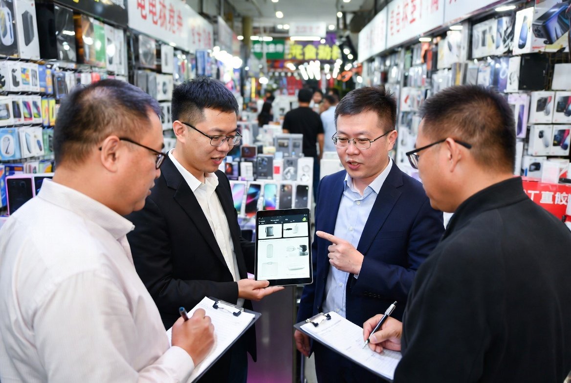China sourcing agent and a group of men standing around a tablet computer