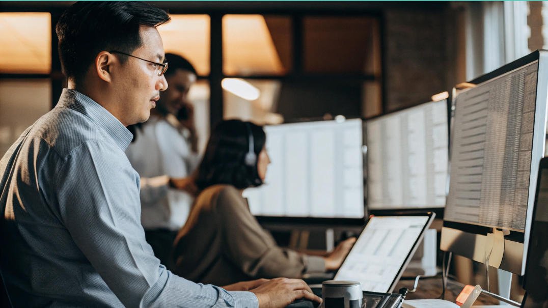 China sourcing agent sitting at a desk with a laptop and a woman