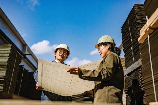 Factory office with Chinese agents reviewing plans outdoors (ID#4)
