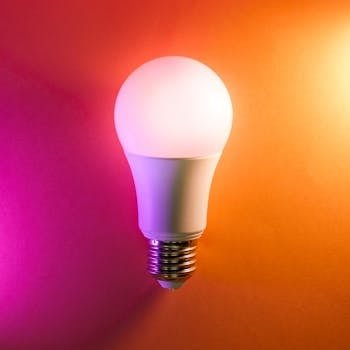 Vibrant LED lightbulb on a colorful gradient background, symbolizing energy efficiency and creativity.