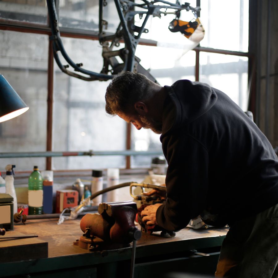 Craftsman working at a workbench on a factory production floor (ID#1)