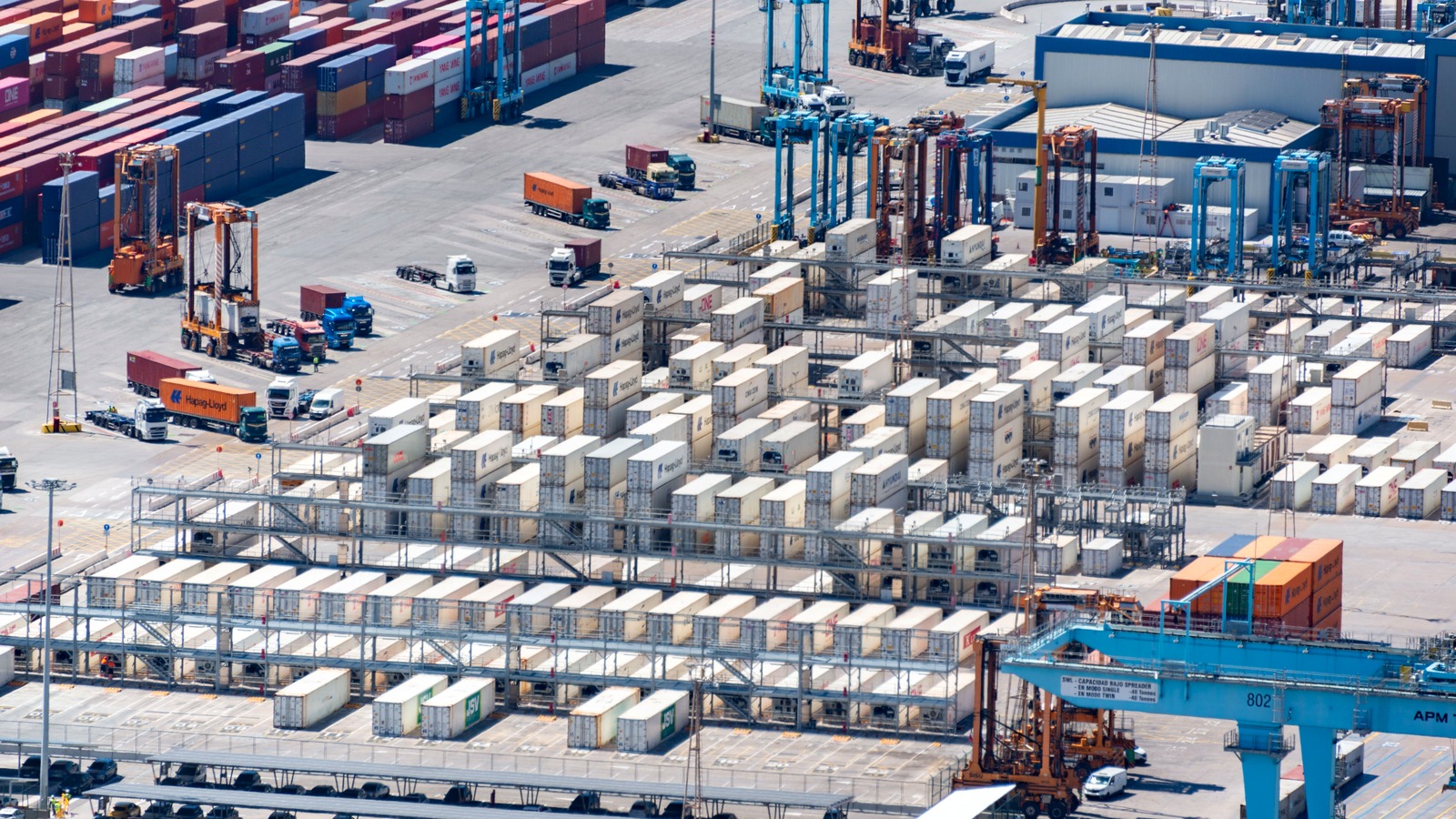 Aerial view of a container port: stacked shipping containers, gantry cranes and container trucks on the apron. US Customs and Border Protection is refunding IEEPA duty on entries of this kind, one entry number at a time.